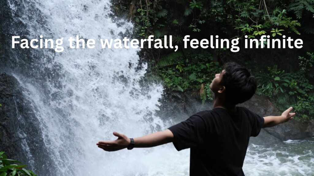 Enjoying Waterfall Captions for Instagram – person happily enjoying a scenic waterfall surrounded by lush green nature, peaceful vibe perfect for Instagram photos.